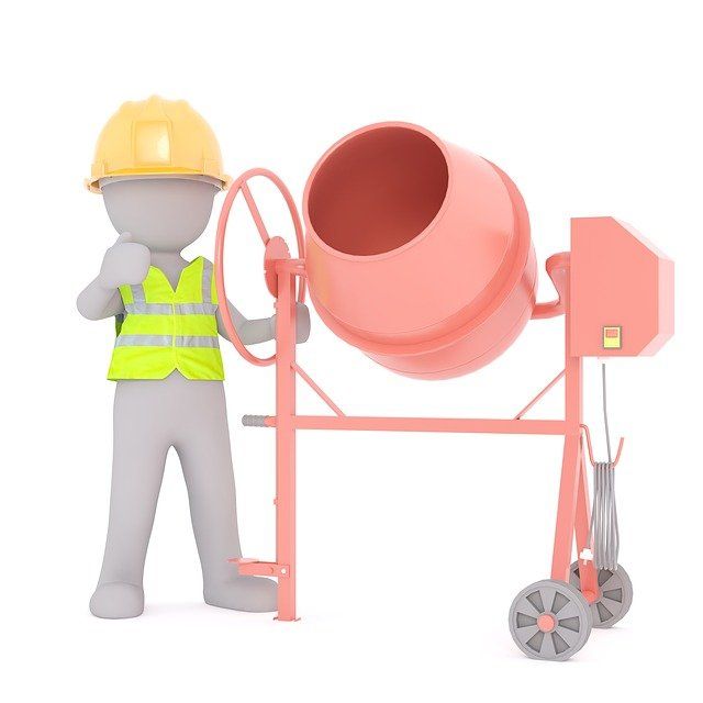 Construction worker troubleshooting a concrete mixer on a job site